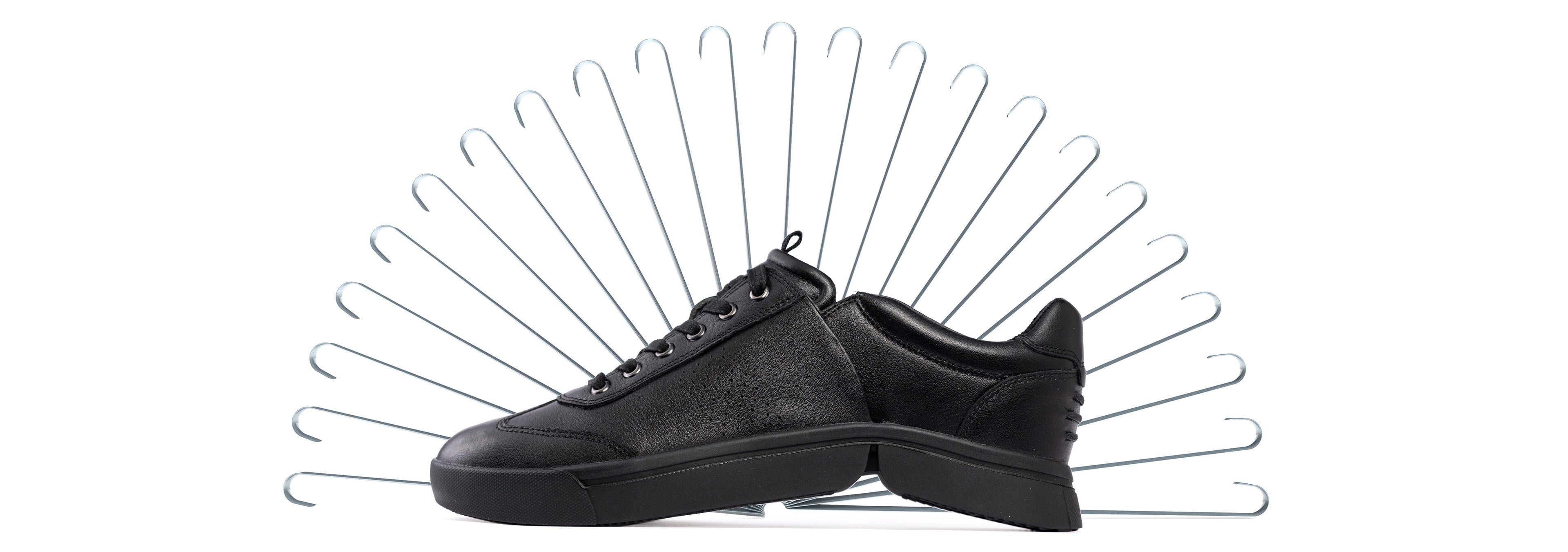 Schwarzer bendys Schuh vor einem Fächer aus Schuhlöffeln: Symbol für freihändiges Anziehen ohne zusätzliche Einstiegshilfe.