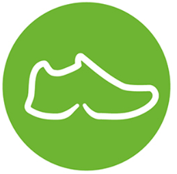 Grünes kreisrundes Icon mit der weißen Silhouette eines bendys Sneakers – Symbol für komfortable und barrierefreie Hands-free Schuhe