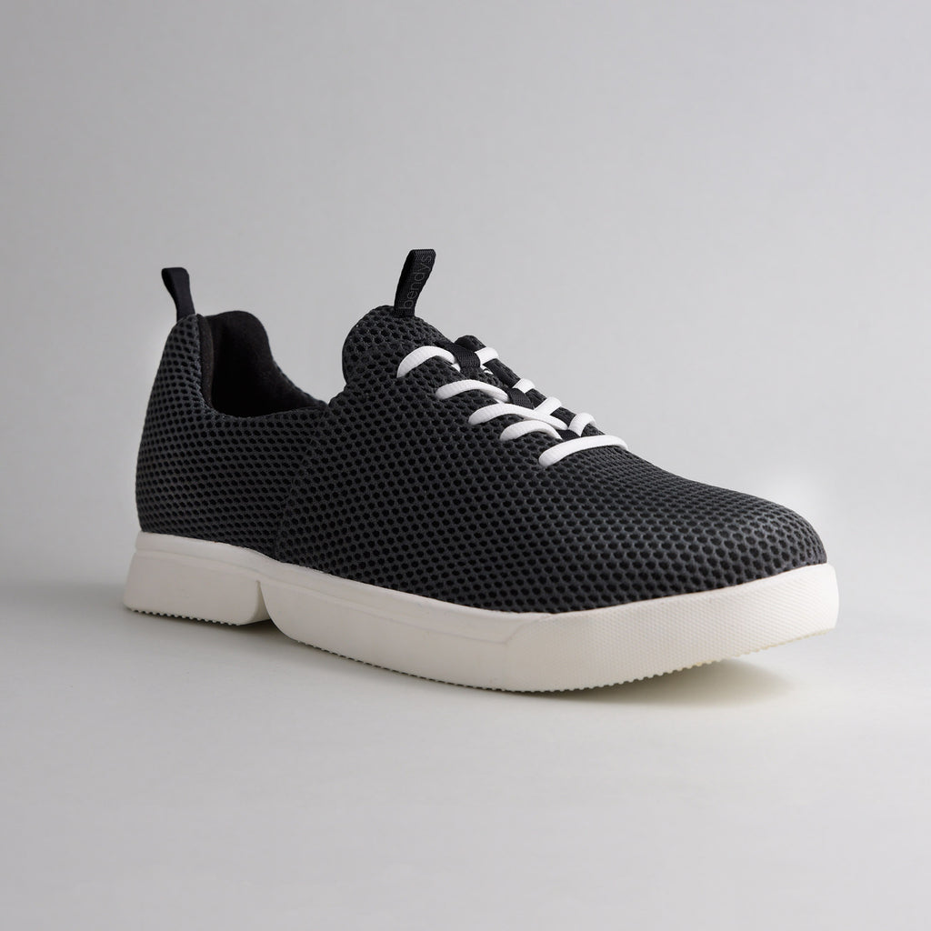 Seitenansicht des schwarzen bendys Mesh-Sneakers im halbgeöffneten Zustand: Deutliche Darstellung der zweigeteilten, weißen Klappsohle, die den händefreien Einstieg ermöglicht