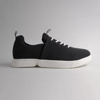 Seitenansicht des schwarzen bendys Mesh-Sneakers im halbgeöffneten Zustand: Deutliche Darstellung der zweigeteilten, weißen Klappsohle, die den händefreien Einstieg ermöglicht