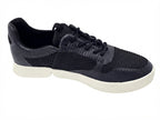 Seitenansicht des flachen schwarzen Sneakers mit flexibler weißer Sohle.